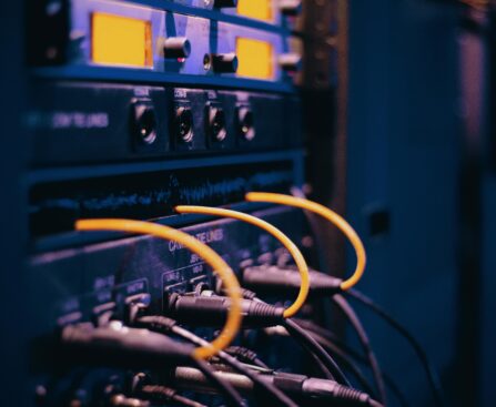 Close-up of network cables and ports in a server rack, showcasing connectivity.