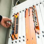 Close-up of a hand adjusting network equipment in a data center.