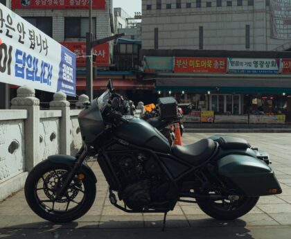 A sleek motorcycle parked in the vibrant streets of Seoul, South Korea, showcasing local architecture.
