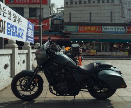 A sleek motorcycle parked in the vibrant streets of Seoul, South Korea, showcasing local architecture.