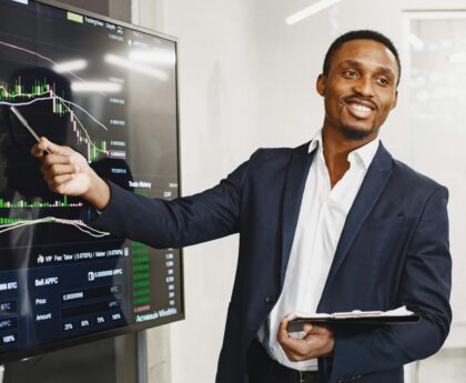 Businessman presents financial data using graphs, showcasing technology and analysis in a corporate environment.