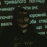 Silhouette of a person with text projected on face against dark background.