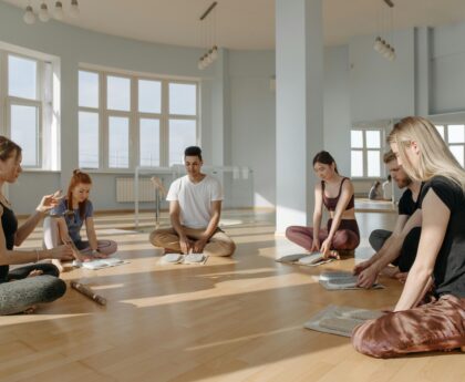 A diverse group of people meditating together indoors, creating a serene and peaceful environment.