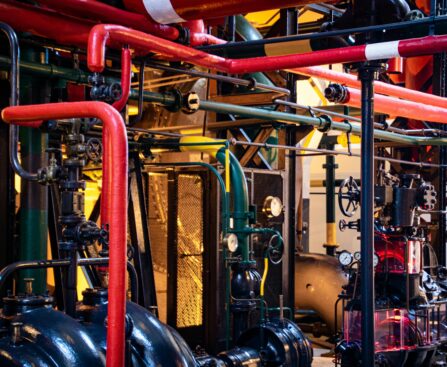 Complex network of industrial pipes and machinery inside a Lisbon plant.