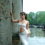 Woman in white dress during an artistic photoshoot in rainy Germany.